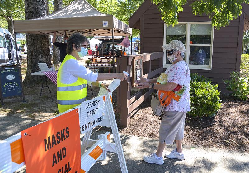 Pat Coluzzi greets every shopper with a squirt of hand sanitizer. DENY HOWETH PHOTOS